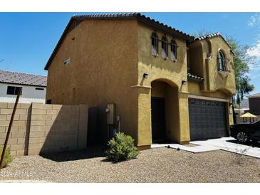 Two-story house with Spanish-style architecture, a two-car garage, and a landscaped front yard at 7213 S 12Th Pl, Phoenix, AZ 85042