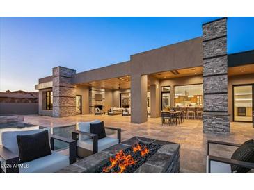 A stunning backyard featuring a pool, fire pit, and seamless indoor-outdoor living with travertine floors at 36323 N 100Th Way, Scottsdale, AZ 85262