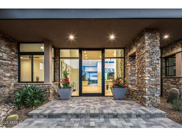 Inviting front entrance with stone accents, modern lighting, and large glass doors at 40575 N 109Th Pl, Scottsdale, AZ 85262