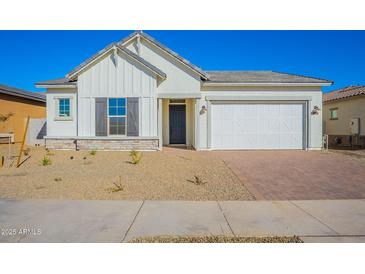 One-story home with white exterior, gray shutters, and a two-car garage at 16430 W Desert Mirage Dr, Surprise, AZ 85388