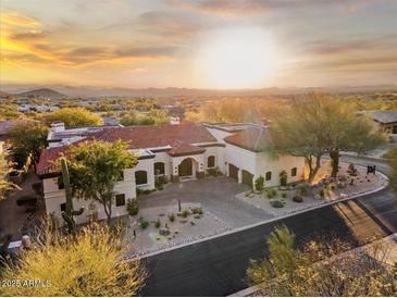Expansive desert home boasting a red tile roof, circular driveway, and stunning sunset views at 10721 E La Junta Rd, Scottsdale, AZ 85255