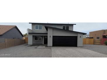 Charming two-story home featuring a modern black garage door and inviting front entrance at 6134 S Borego Rd, Gold Canyon, AZ 85118