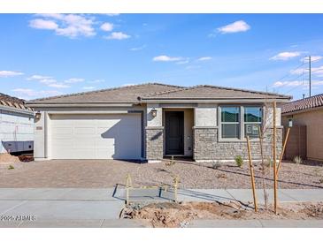 Charming single-story home with stone accents, a two-car garage, and a well-maintained front yard under a blue sky at 16766 W Yucatan Dr, Surprise, AZ 85388