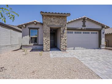 Charming single-story home featuring a stone-accented entrance, a two-car garage, and low-maintenance desert landscaping at 31969 N 117Th Ave, Peoria, AZ 85383