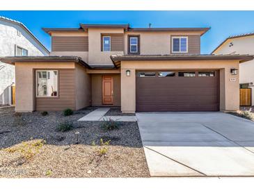 Inviting two-story home with a two-car garage, desert landscaping, and a charming peach-colored front door at 9239 E Spiral Ave, Mesa, AZ 85212
