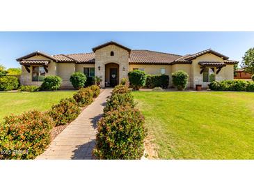 Charming single-story home featuring a stone facade, tile roof, manicured lawn, and inviting landscape at 19575 E Vallejo St, Queen Creek, AZ 85142
