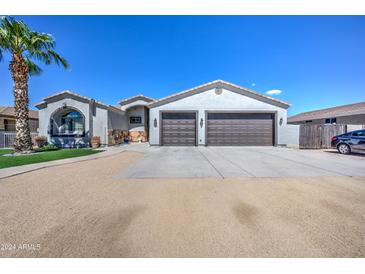 Two-car garage and desert landscaping characterize this charming home's exterior at 10228 E Broadway E Rd, Mesa, AZ 85208