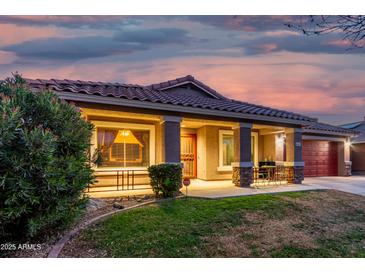 House exterior at dusk, featuring a covered porch and well-manicured lawn at 16567 W Mckinley St, Goodyear, AZ 85338