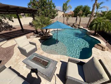Backyard pool with seating, fire pit, and lush tropical landscaping for outdoor entertaining at 4142 E Zion Pl, Chandler, AZ 85249