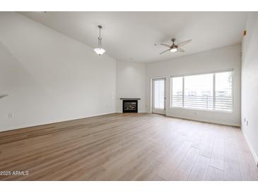 Bright living room features wood floors, fireplace, and sliding doors to a balcony at 4525 N 22Nd St # 404, Phoenix, AZ 85016