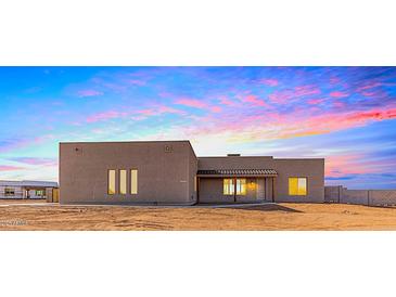 Single-story home with stucco exterior, neutral color palette, and a covered porch at 23120 W Skinner Rd, Wittmann, AZ 85361