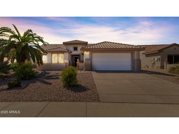 One-story home with tile roof, two-car garage, and desert landscaping at 15713 W Star View Ln, Surprise, AZ 85374