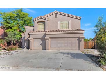 Two-story house with tan exterior, two-car garage, and landscaped front yard at 648 W Cobblestone Dr, Casa Grande, AZ 85122