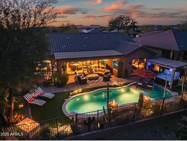 Luxury home with a private pool, spa, and expansive backyard at dusk at 40903 N Harbour Town Way, Anthem, AZ 85086