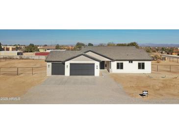 New construction home with two-car garage and desert landscaping at 25721 W Running Deer Trl, Wittmann, AZ 85361