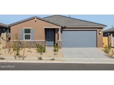 Single-story home with gray garage door and desert landscaping at 22502 W Tonopah Dr, Surprise, AZ 85387