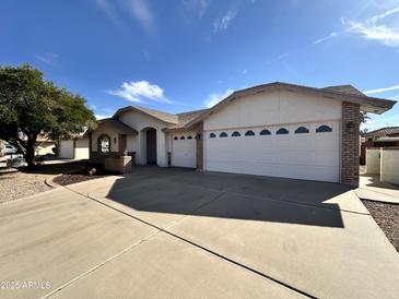 Charming single-story home with a three car garage and a well-maintained front yard at 8217 E Natal Ave, Mesa, AZ 85209