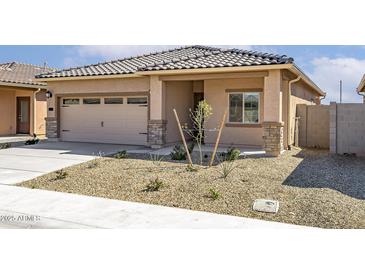 Charming home featuring a tile roof, low maintenance desert landscaping, and an attached two car garage at 24629 W St Catherine Ave, Buckeye, AZ 85326