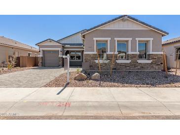 Charming single-story home showcasing a stone and stucco exterior with a well-manicured front yard at 12003 W Parkway Ln, Avondale, AZ 85323