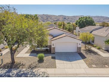 Charming home featuring a manicured front yard, a spacious two-car garage, and desert landscaping at 2223 E Branham Ln, Phoenix, AZ 85042
