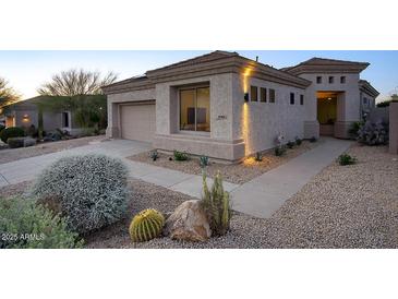 Charming home exterior with desert landscaping, complemented by a well-maintained walkway and stucco facade at 11566 E Christmas Cholla Dr, Scottsdale, AZ 85255