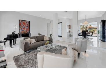 Bright living room with piano, modern art, stylish furniture, and a view to the dining area at 9175 N 82 St, Scottsdale, AZ 85258