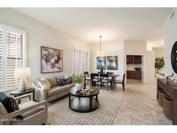 Bright living room featuring modern furnishings, neutral tones, and abundant natural light from shuttered windows at 10851 E Le Marche Dr, Scottsdale, AZ 85255