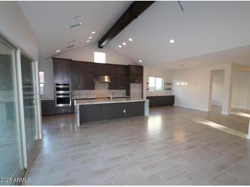 Open kitchen features stainless appliances, a center island, and custom cabinets at 19964 W Marshall Ave, Litchfield Park, AZ 85340