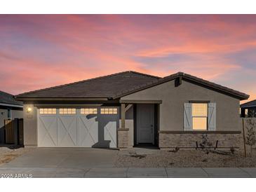 Single story home with a two-car garage and desert landscaping at 37422 W San Clemente St, Maricopa, AZ 85138