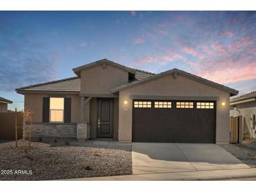 Single-story home with a two-car garage and desert landscaping at 37501 W San Clemente St, Maricopa, AZ 85138