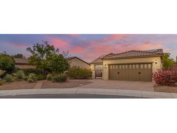 Beautiful desert home exterior with landscaped yard and two-car garage at 12368 W Running Deer Trl, Peoria, AZ 85383