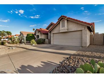 Charming single story home with a red tile roof, two car garage, and desert landscaping at 11035 E Clinton St, Scottsdale, AZ 85259