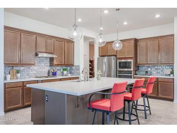 Modern kitchen featuring a large island, stainless steel appliances, and stylish pendant lighting at 14133 S 179Th Ave, Goodyear, AZ 85338