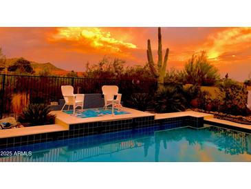 Inviting backyard pool area with stylish patio furniture and desert landscaping at sunset at 4333 S Pony Rider Trl, Gold Canyon, AZ 85118