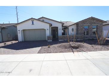 Charming single-story home featuring a neutral color palette, well-manicured landscaping, and an attached two-car garage at 12315 W Parkway Ln, Avondale, AZ 85323