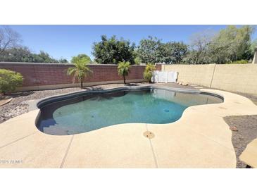 Inviting backyard pool with a pebble tec surround and mature landscaping for a private oasis at 15409 W Corrine Dr, Surprise, AZ 85379