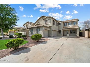 Charming two-story home showcasing desert landscaping, a spacious driveway, and a welcoming facade, inviting you to explore further at 1392 E Baker Dr, San Tan Valley, AZ 85140