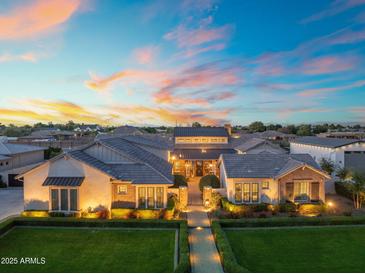 Stunning exterior of a home featuring manicured lawns, elegant landscaping, and a welcoming entrance with beautiful sunset views at 2652 E Pelican Ct, Gilbert, AZ 85297