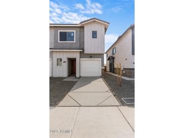 Two-story townhome with attached garage and modern architectural details at 7453 S 75Th Dr, Laveen, AZ 85339