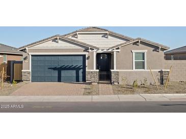 One-story home with a dark-blue garage door and landscaped front yard at 17798 W Coolidge St, Goodyear, AZ 85395