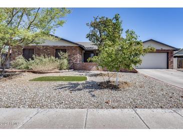 Brick ranch house with a landscaped front yard, and a two-car garage at 19219 N 33Rd Ave, Phoenix, AZ 85027