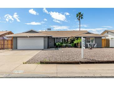 Charming single-story home with a well-manicured front yard, complemented by a white two-car garage and desert landscaping at 3425 W Acoma Dr, Phoenix, AZ 85053