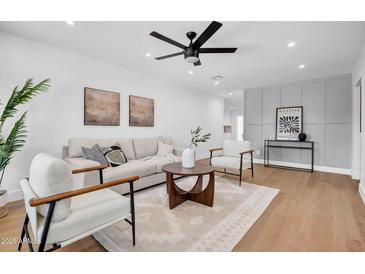 Bright living room with a ceiling fan, modern decor, light hardwood floors and lots of natural light at 2126 E Watson Dr, Tempe, AZ 85283