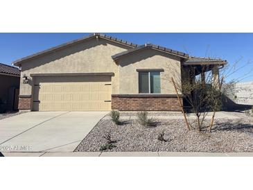 One-story house with beige stucco and brick accents, featuring a two-car garage and desert landscaping at 4075 N Ghost Hollow Way, Casa Grande, AZ 85122