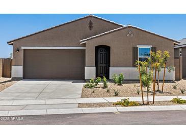 Inviting single-story home featuring a two-car garage, desert landscaping, and a classic brown stucco facade at 20357 N 225Th Dr, Surprise, AZ 85387