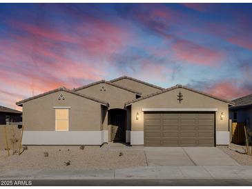 Tan two-story house with brown garage door, landscaping, and a twilight sky at 36954 W La Paz St, Maricopa, AZ 85138