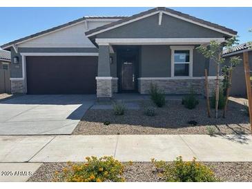Charming single-story home featuring a stone accent facade and a two-car garage at 20331 N 225Th Dr, Surprise, AZ 85387