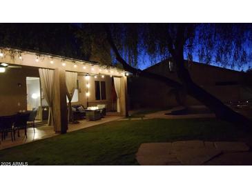 Covered patio with string lights, seating area, and fire pit at 4958 E Desert Vista Trl, Cave Creek, AZ 85331