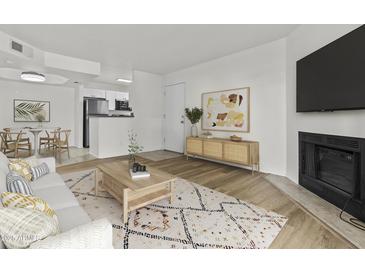 Cozy living room featuring a fireplace, open floor plan, and modern decor at 3845 E Greenway Rd # 131, Phoenix, AZ 85032