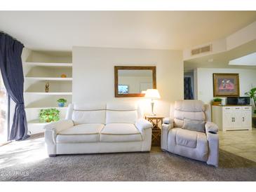 Bright living room features comfy seating and built-in shelving at 3845 E Greenway Rd # 131, Phoenix, AZ 85032